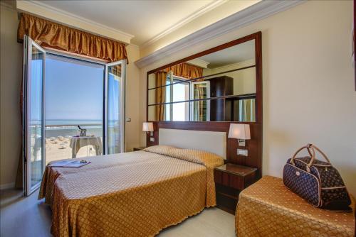 um quarto com 2 camas e um espelho grande em Hotel Caesar Paladium em Rimini