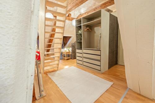 a room with a hallway with a refrigerator and a rug at Loft avec vue sur la Cathédrale de Fribourg in Fribourg