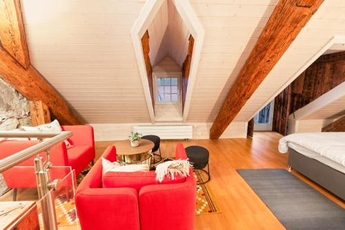 a living room with a red couch and a bed at Loft avec vue sur la Cathédrale de Fribourg in Fribourg