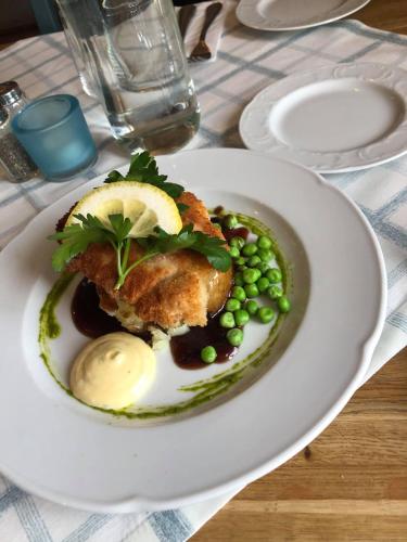 a plate of food with meat and peas on a table at Wärdshuset Gammel Tammen Österbybruk in Österbybruk