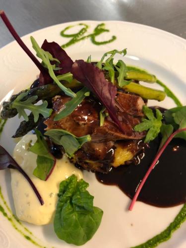 a plate of food with meat and vegetables on it at Wärdshuset Gammel Tammen Österbybruk in Österbybruk
