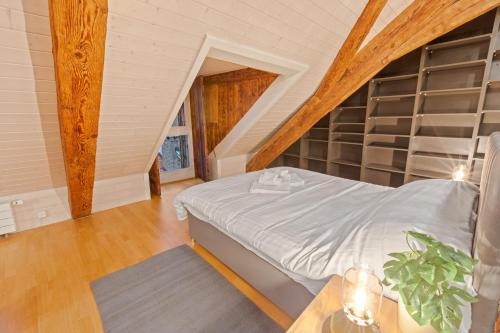 a attic bedroom with a bed and a table at Loft avec vue sur la Cathédrale de Fribourg in Fribourg