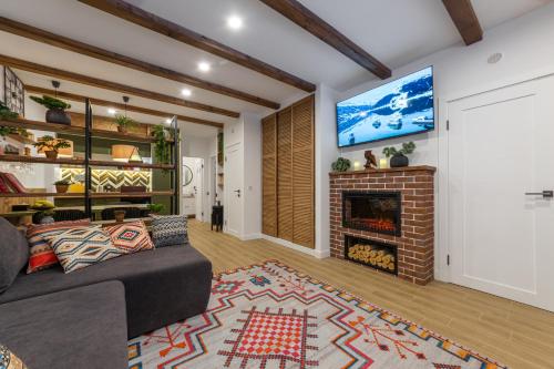 Una sala de estar con un sofá y una chimenea. en Цілий триповерховий будинок Freeman-3 над річкою з альтанкою та грилем - СВІТЛО Є ЗАВЖДИ, en Bukovel
