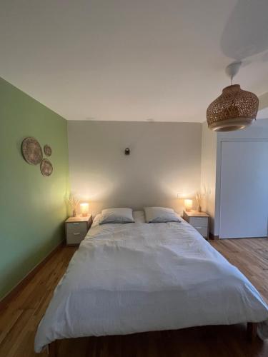 une chambre avec un grand lit blanc avec deux lampes dans l'établissement Joli Duplex Centre Montpellier, à Montpellier