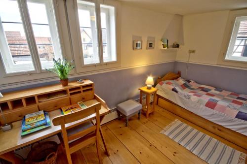 Un dormitorio con una cama, un escritorio y una ventana. en Ferienhaus Austragshaus, en Stockheim