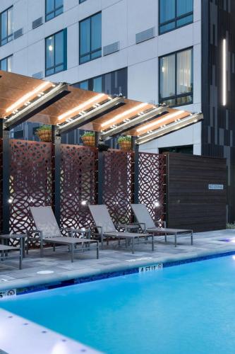 a group of chairs sitting next to a swimming pool at Courtyard by Marriott Houston Heights/I-10 in Houston