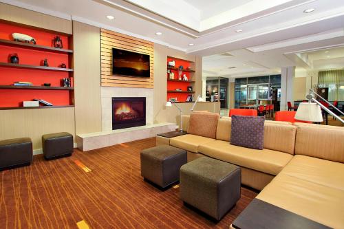 a living room with a couch and a fireplace at Courtyard Oakland Downtown in Oakland