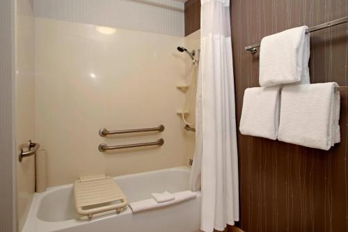 a bathroom with a tub and a toilet and towels at Courtyard Oakland Downtown in Oakland