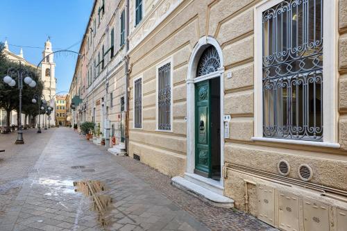 a building with a green door on a street at Casa al mare in Pietra Ligure