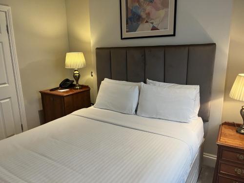 a bed with white sheets and pillows in a hotel room at Staunton Hotel - B&B in London