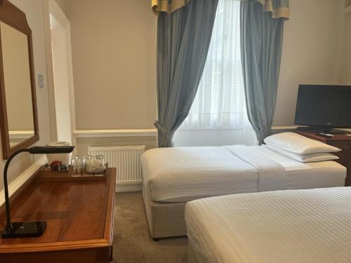 a hotel room with two beds and a window at Staunton Hotel - B&B in London