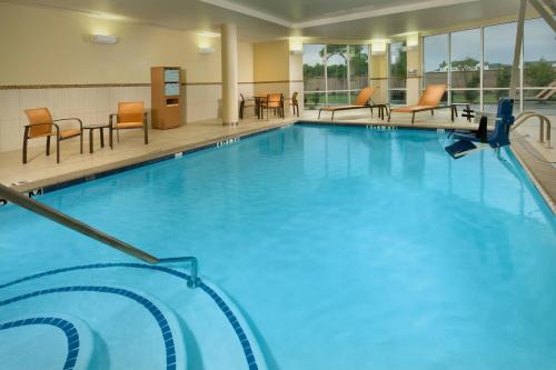 a large swimming pool with chairs and tables at Courtyard Houston NW/290 Corridor in Houston