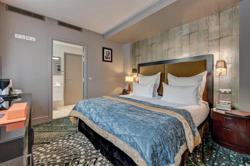 a hotel room with a bed and a bathroom at The One Alma Paris in Paris