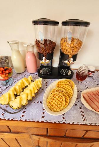 a table with waffles and other food on it at Pousada Noa in Cabo Frio