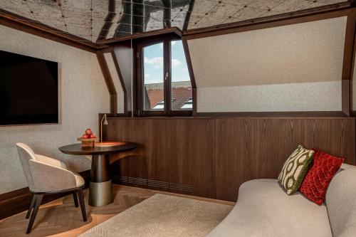 a room with a bed and a table and a window at Almanac Palais Vienna in Vienna