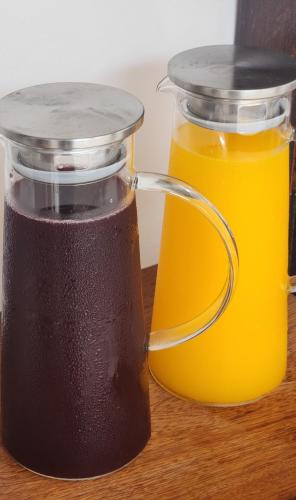two jars of orange juice on a wooden table at Pousada Noa in Cabo Frio