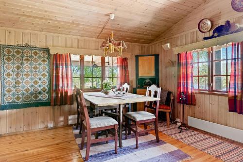 a dining room with a wooden table and chairs at Traditional Cabin By Reinsvatn In Treungen in Treungen
