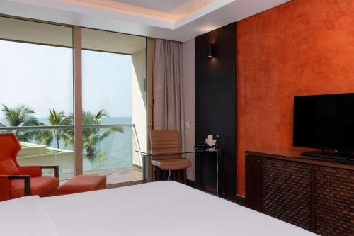 a hotel room with a bed and a large window at Radisson Blu Hotel, Conakry in Conakry