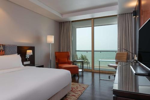 a hotel room with a bed and a view of the ocean at Radisson Blu Hotel, Conakry in Conakry