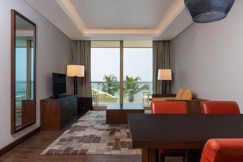 a living room with a television and a table and chairs at Radisson Blu Hotel, Conakry in Conakry