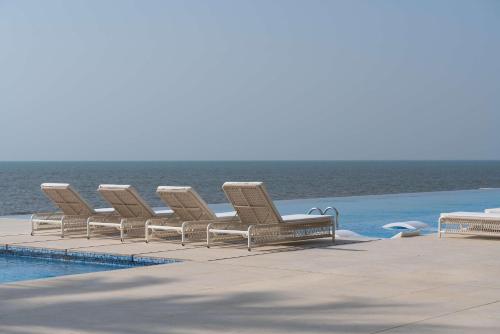 a row of lounge chairs next to a swimming pool at Radisson Blu Hotel, Conakry in Conakry
