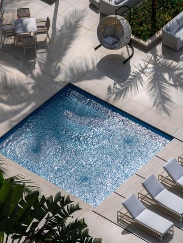 an overhead view of a swimming pool with chairs and a patio at Radisson Blu Hotel, Conakry in Conakry