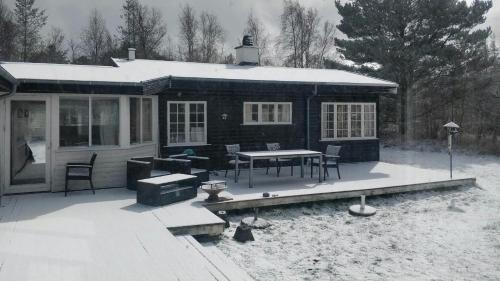 a house with a table and chairs in the snow at Atmosphere And Space At The Home By Vig in Vig
