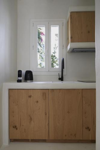 a kitchen with wooden cabinets and a window at Aerina Residences in Platis Gialos