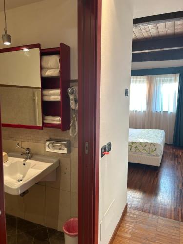 a bathroom with a sink and a bedroom with a bed at Cascina Scova Resort in Pavia