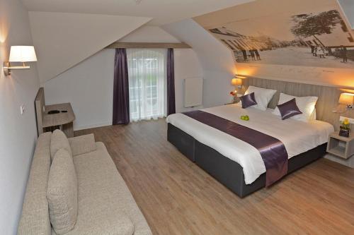 a hotel room with a large bed and a couch at Best Western City Hotel Woerden in Woerden
