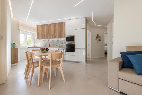 a kitchen and dining room with a table and chairs at Apartamento novo junto ao metro - 1D in Lisbon