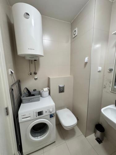 Un baño con lavadora y un inodoro. en Marse Stay, en Belgrado