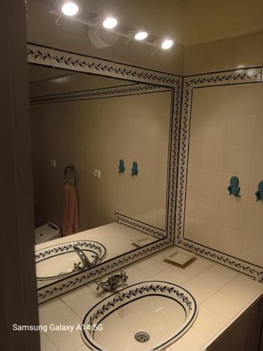 a bathroom with two sinks and a large mirror at Confort, fun and leisure in Douro Rural Space in Sande