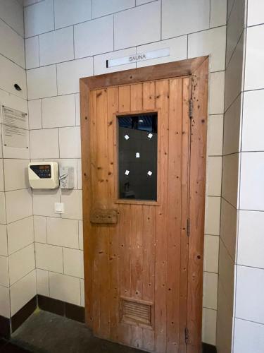 a wooden door in a bathroom with a phone at Urban 360 Studio Love Rara Suite Homestay in Batu Caves