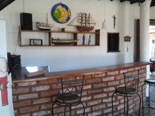 a bar with two chairs and a brick wall at Posada la Arcadia in Pedro Gonzalez