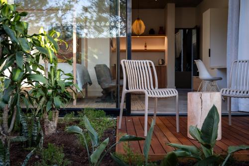 two white chairs sitting on a wooden deck at Khiwane Boutique Hotel in Hoedspruit