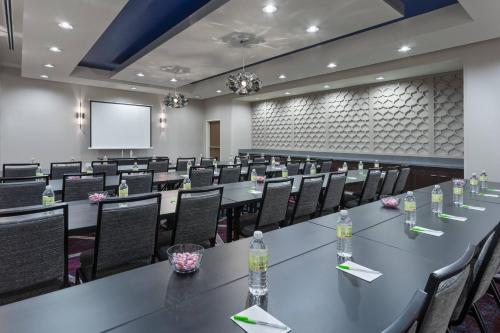 a conference room with tables and chairs and a screen at Courtyard by Marriott Houston Katy Mills in Katy