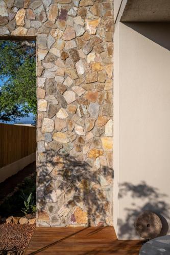 a stone wall with a mirror on the side of a house at Khiwane Boutique Hotel in Hoedspruit