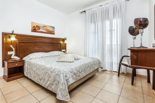 a bedroom with a bed with a wooden headboard at Nereides Hotel in Hanioti