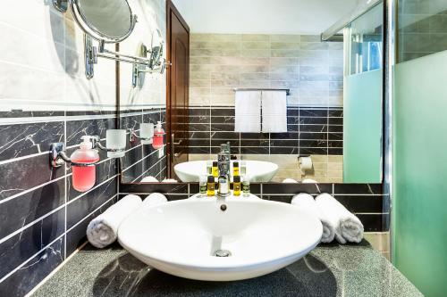 baño con 2 lavabos y espejo grande en Nereides Hotel, en Chaniotis