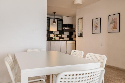 a dining room with a white table and chairs at Sea view 2 bedroom apartment in Haifa