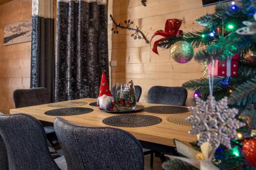 a table with christmas decorations and a christmas tree at Leśny Dwór Premium Chalets Zakopane in Murzasichle
