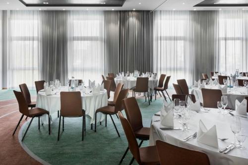a conference room with white tables and chairs and windows at Courtyard by Marriott Basel in Pratteln