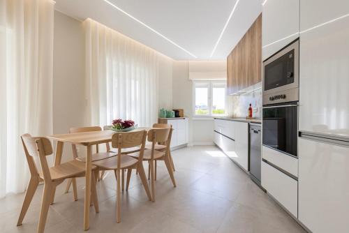 a kitchen with a wooden table and chairs in a room at Apartamento novo junto ao metro - 1D in Lisbon