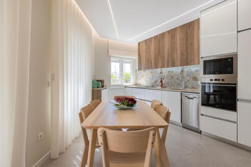 a kitchen with a wooden table and chairs at Apartamento novo junto ao metro - 1D in Lisbon