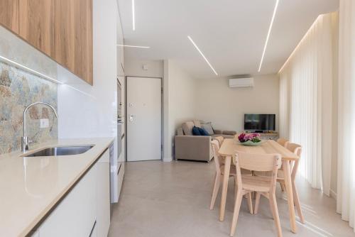a kitchen and dining room with a table and chairs at Apartamento novo junto ao metro - 1D in Lisbon