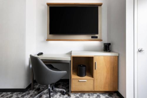 a desk with a chair and a television on a wall at Courtyard New York Downtown Manhattan/Financial District in New York