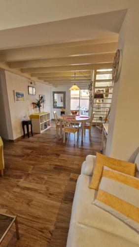 ein Wohnzimmer mit einer weißen Couch und einem Tisch in der Unterkunft VILLA CITRONNELLE Grande maison 2 chambres avec jardin proche plage - Clim - Wifi in Saint Cyprien Plage