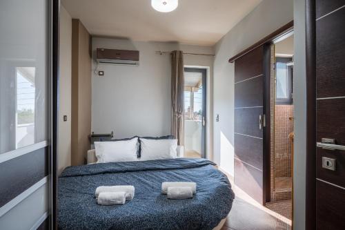 a bedroom with a bed with two towels on it at Indoor pool villa, near the beach, Lagonisi in Kalívia Thorikoú
