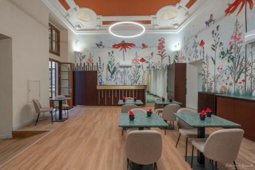 a waiting room with tables and chairs and flowers on the wall at Hotel Adamas in Florence